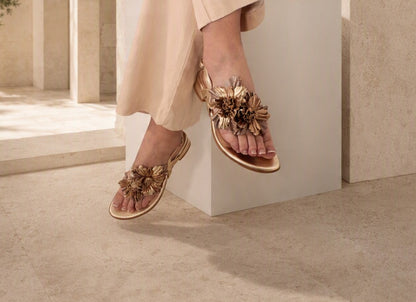 Close-up of Paloma sandal worn, showing floral corsage detail on foot