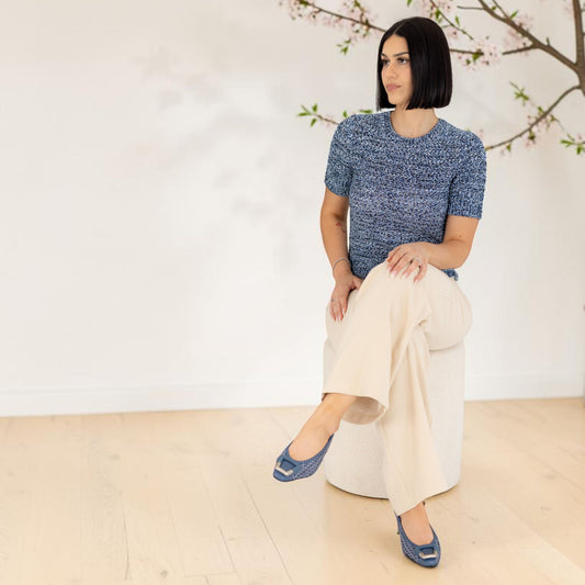 Model wearing Mara Jean leather slingback sandals, seated lifestyle shot, by Estela