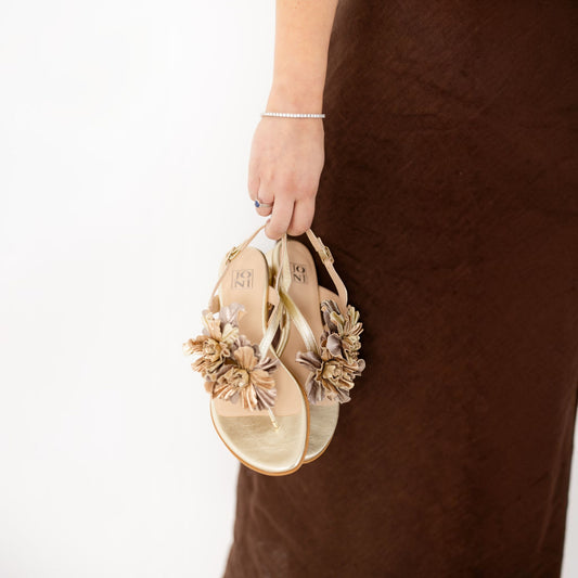 Model wearing Paloma Gilded Trio gold metallic sandals, lifestyle shot, by Estela