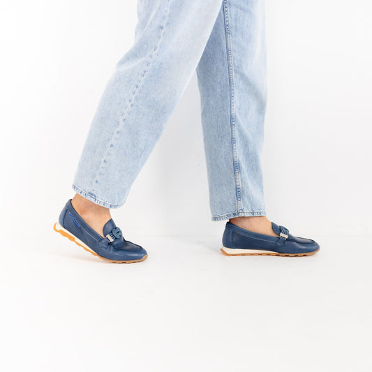 Model wearing Lucía Jean leather loafers, walking in jeans, by Estela