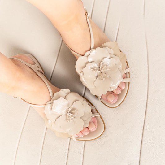 Model wearing Dalia Champagne Pearl floral leather sandals, lifestyle shot, by Estela