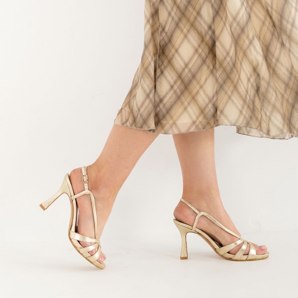 Model wearing Perla Golden Pearl metallic leather sandals, lifestyle shot, by Estela